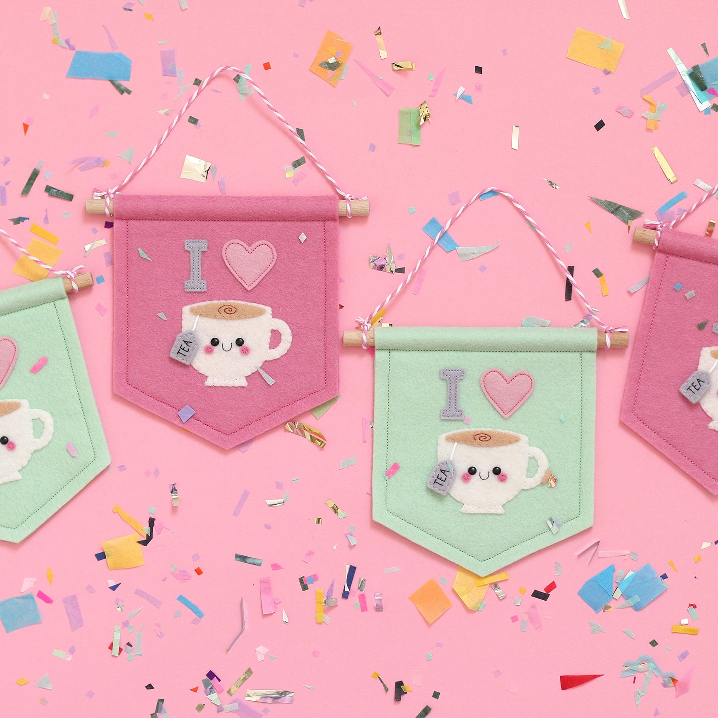 Felt Tea Banners featuring a Kawaii teacup with a happy face. The teacups have "I" and a heart above them. In this image the pink and mint style tea banners can be seen.