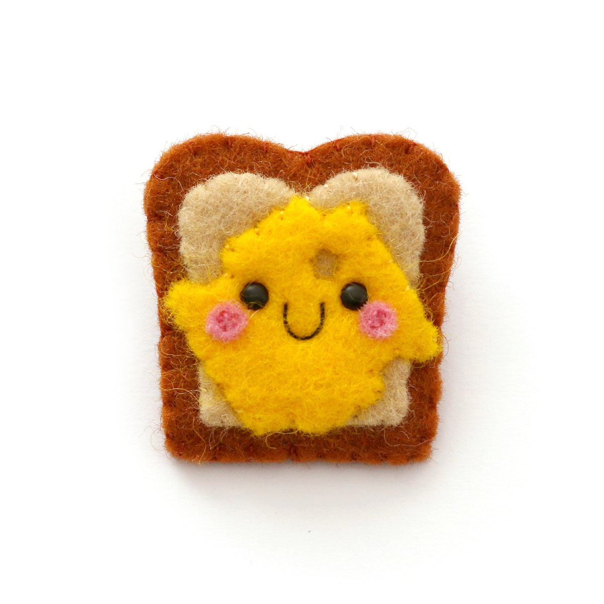 A cute felt brooch shaped like a slice of toast with yellow cheese on it, displayed on a clean white background.