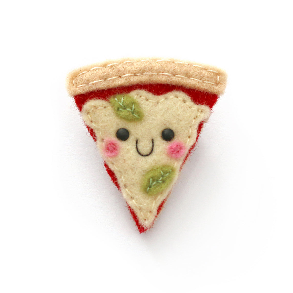 A cute, handcrafted felt pizza slice pin badge accessory with a smiling face, embroidered green basil leaves, pink cheeks, and a beige crust, shown on a plain white background.