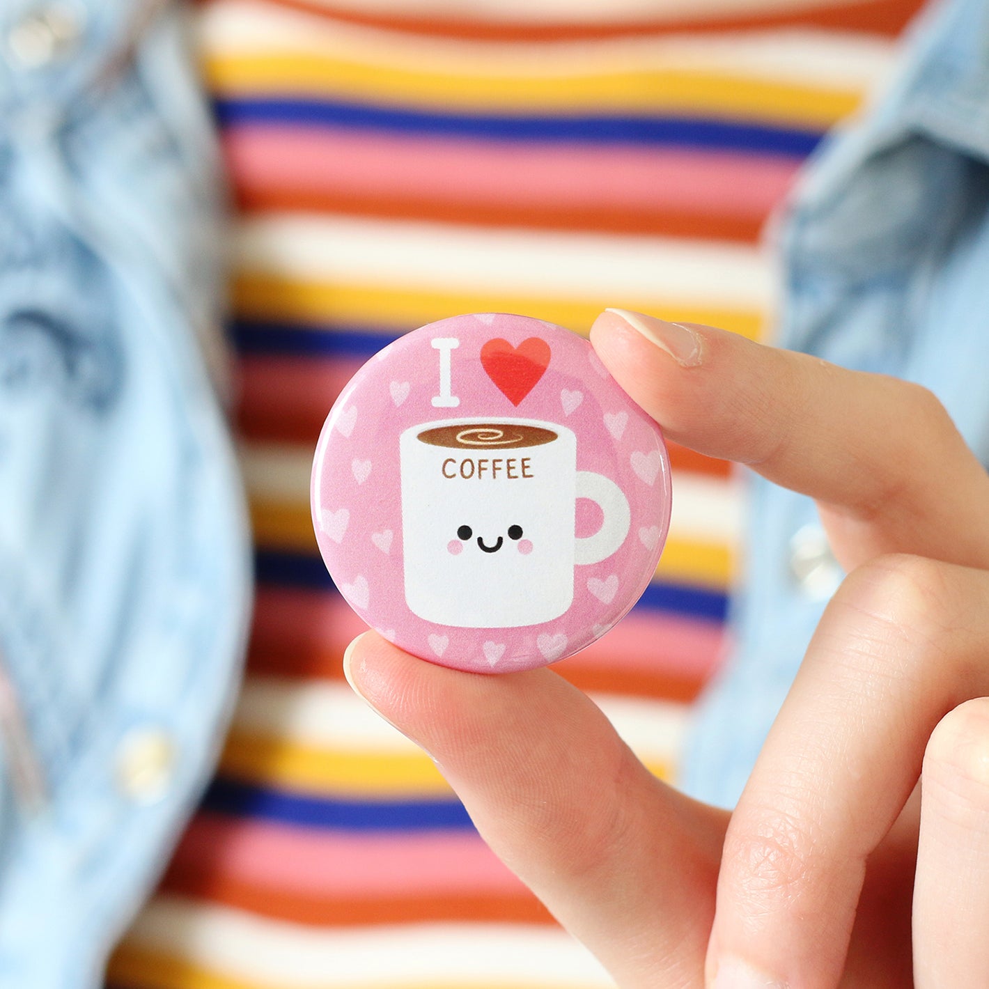 Person holding coffee button badge