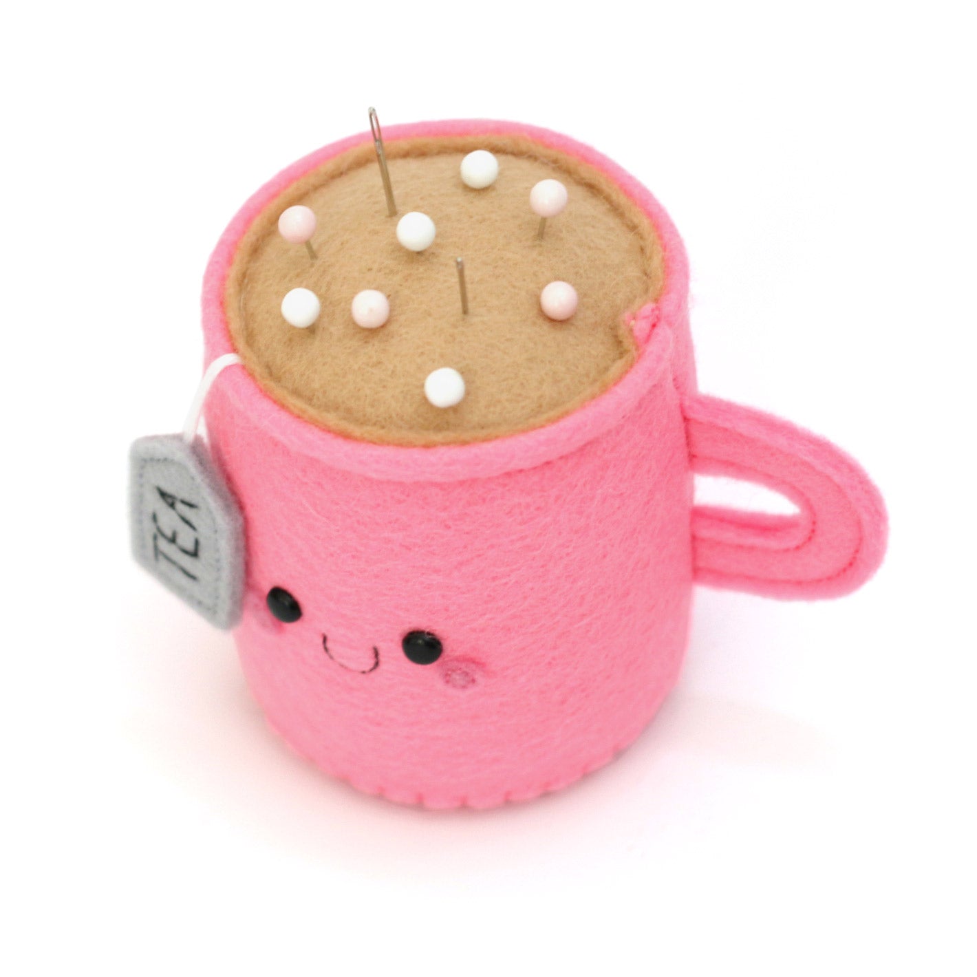 Bright pink teacup pincushion showing top of pincushion holding pins