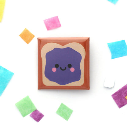 A happy sandwich badge with a spread of purple jelly