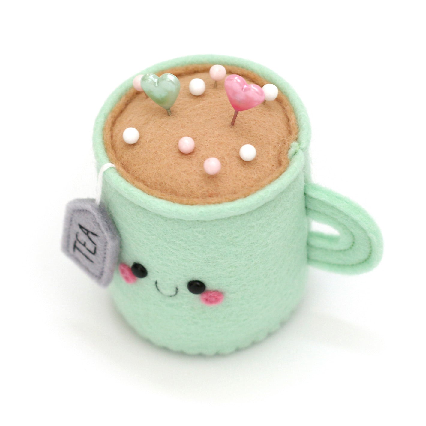 Top view of kawaii mint teacup pincushion with pins by hannahdoodle